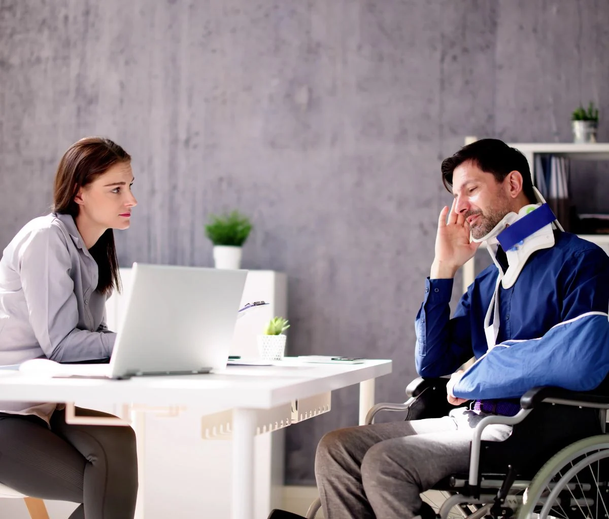Woman consulting with a man in a wheelchair.