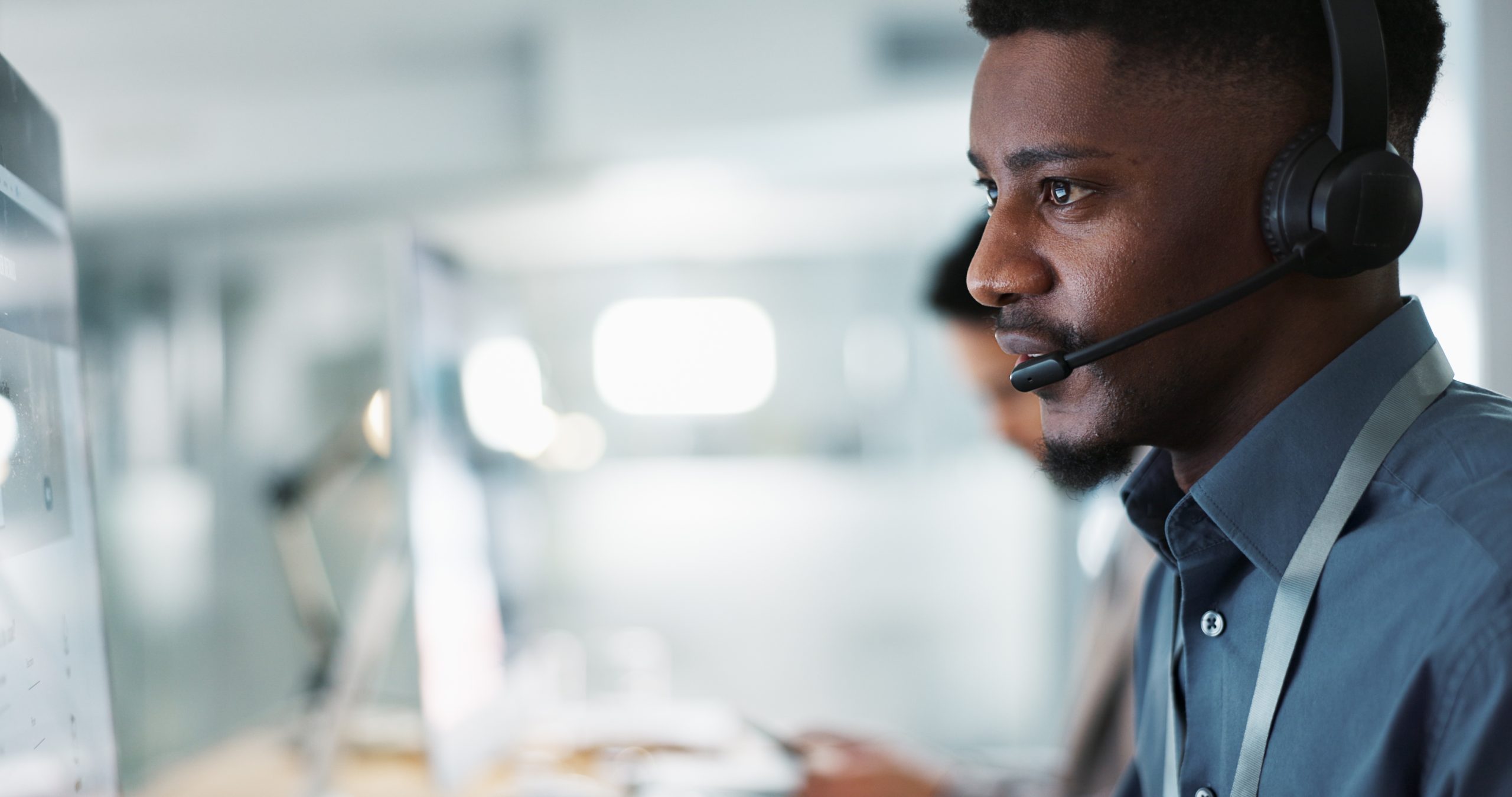 Man wearing headset at computer workstation.